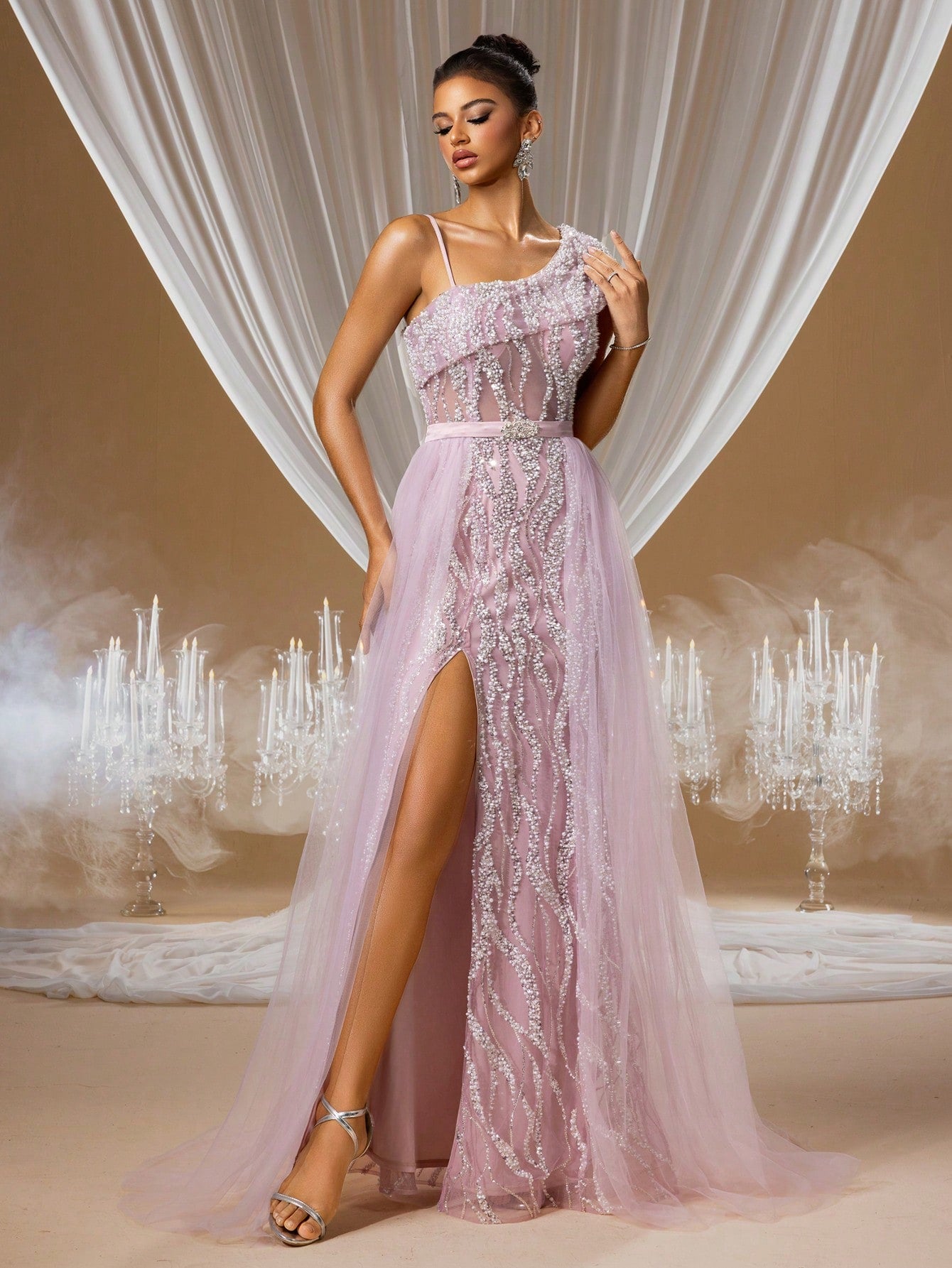 Woman wearing a charming Lavender Quartz mermaid evening gown with a one-shoulder illusion design, intricate crystal embroidery on the bodice, and a voluminous layered tulle skirt with a high slit.